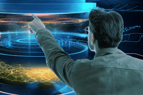 Ein Mann in einer Jacke interagiert mit einer großen, futuristischen, kreisförmigen digitalen Schnittstelle, die blau und orange leuchtende Elemente anzeigt.
